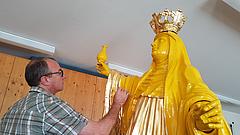 Kirchenmaler Gerhard Hammerschmid vergoldet die Statue der hl. Walburga. Foto: Geraldo Hoffmann